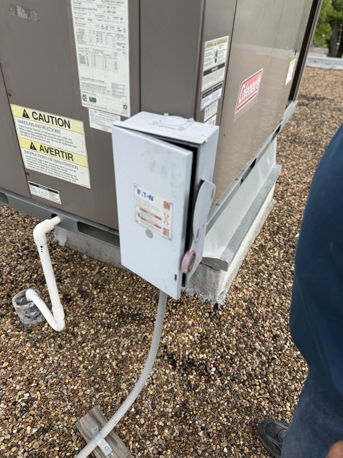 Newly installed disconnect and conduit feeding a rooftop HVAC package unit