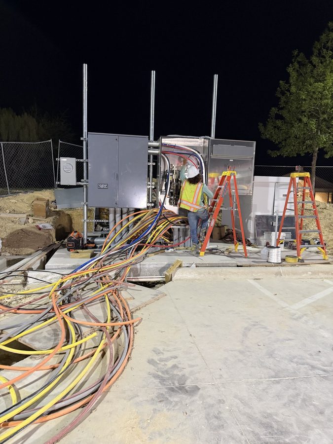 Crew member on a ladder at a switchgear enclosure during a night call