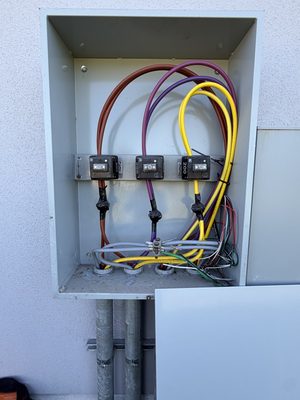 Open meter-socket cabinet with conductors routed neatly to three 200-amp meter sockets