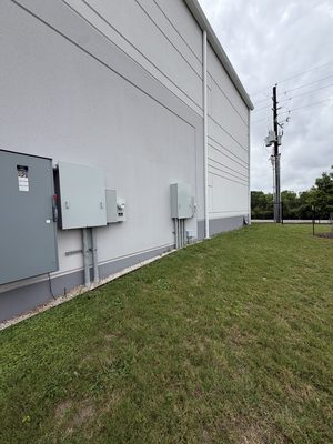 Exterior building wall with two complete panel and meter clusters installed