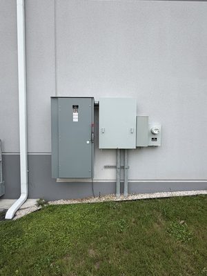 Wall-mounted commercial disconnect, panel and meter cluster installed as one clean assembly