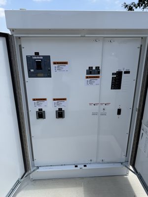 Open EV charger cabinet showing the breaker and the applied arc-flash warning labels