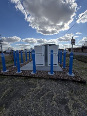 DC fast-charging power cabinets seen from close range against heavy cloud