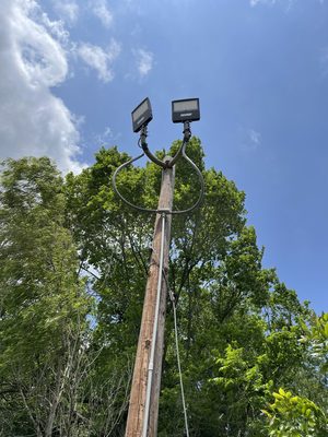 Wood utility pole topped with two new commercial LED floodlights