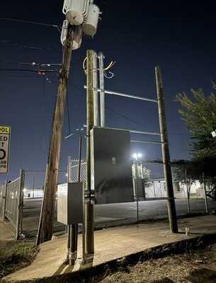 New enclosure and conduit risers lit against a dark night sky