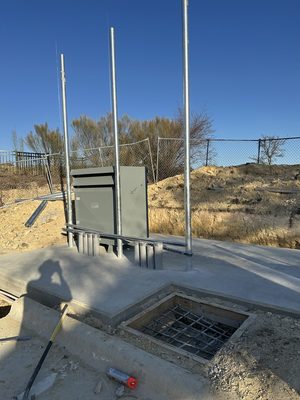 Green padmount transformer and meter risers set on a new concrete pad