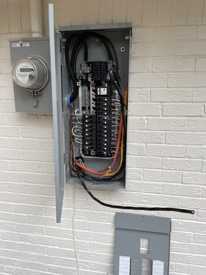 Residential meter and open 200-amp panel mid-upgrade with new breakers and loomed conductors