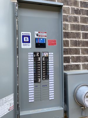 Residential exterior load center with an Eaton surge protective device installed in the panel, its status light green, and every circuit hand-labeled on the directory beside it