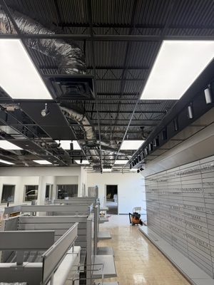 Retail finish-out lit with large flat LED ceiling panels and black track heads