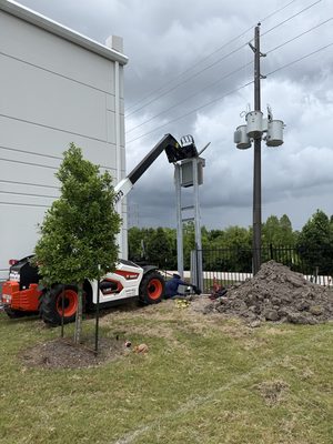 New riser structure with a worker at its base under building storm clouds