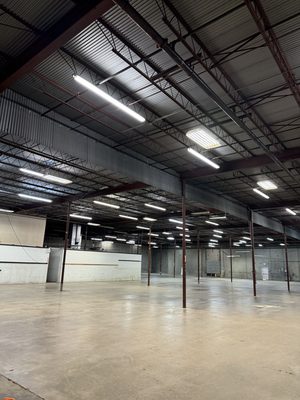 Large warehouse interior with new overhead LED strip lighting on the steel structure